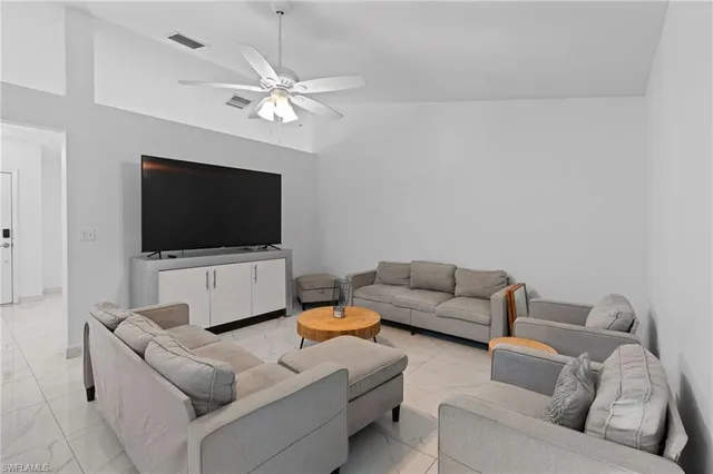 a living room with furniture a fireplace and a large window