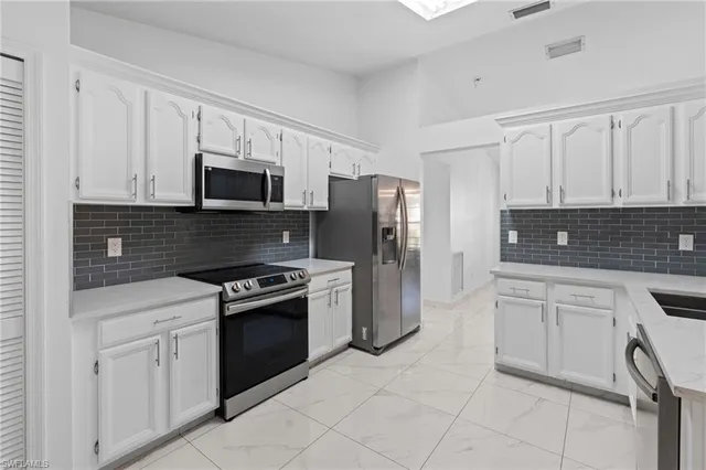a kitchen with stainless steel appliances granite countertop a refrigerator sink and stove