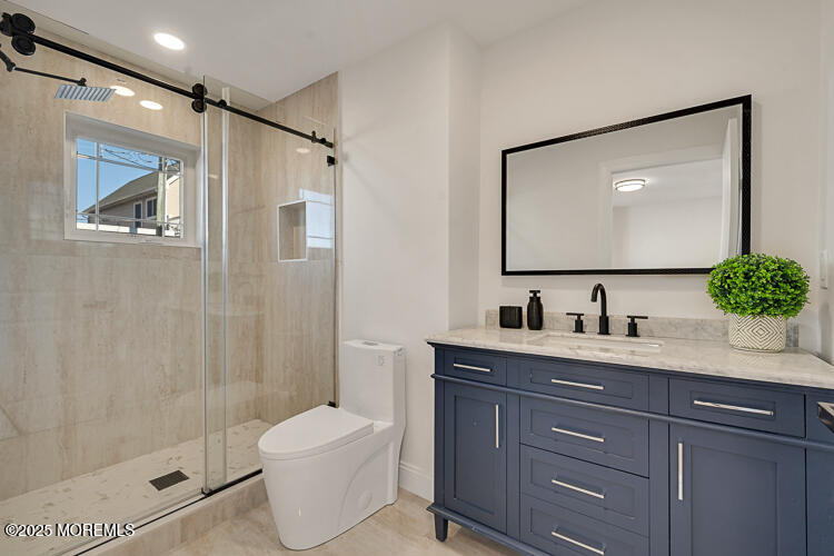 24 Surf Street Sea Bright, NJ 07760 - Photo 15 of 51 a bathroom with a granite countertop sink toilet a mirror a vanity and shower
