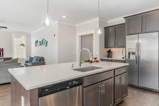 a kitchen with a sink a kitchen island and stainless steel appliances