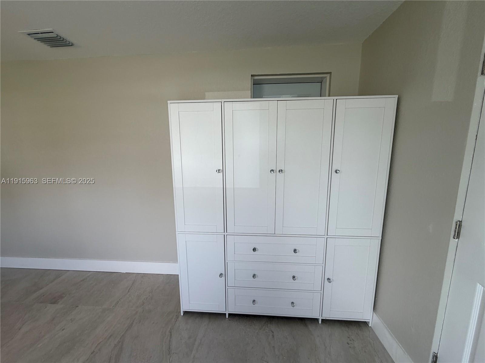 7330 Southwest 11th Street, Unit EFFICIENCY Miami, FL 33144 - Photo 4 of 12 an empty room with cabinet