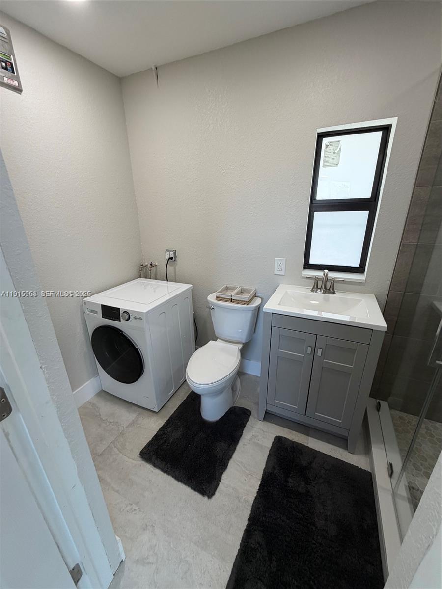 7330 Southwest 11th Street, Unit EFFICIENCY Miami, FL 33144 - Photo 8 of 11 a bathroom with a toilet a sink and a mirror