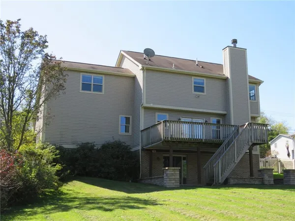 a view of a house with pool and a yard