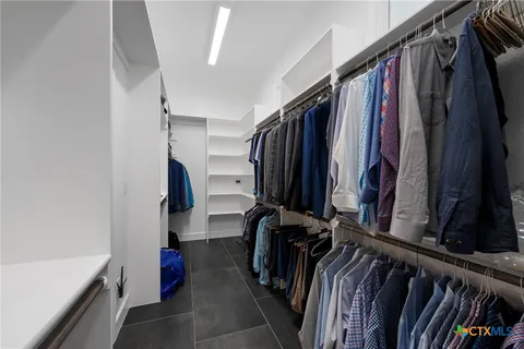 a view of walk in closet with clothes and shoes