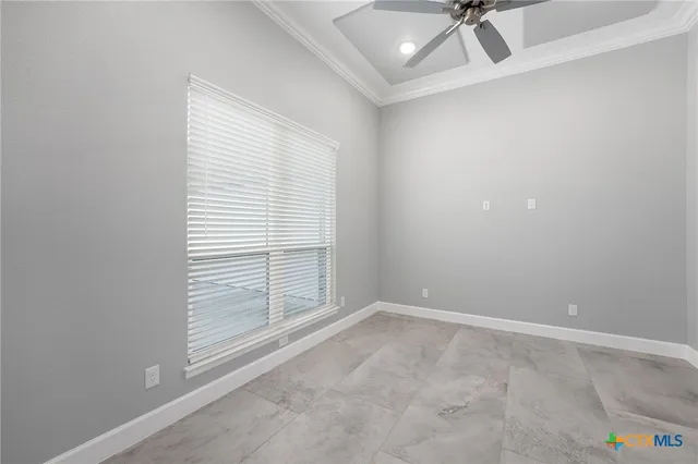 an empty room with a window and a ceiling fan