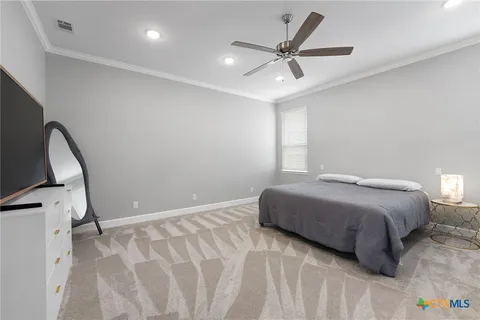 a bedroom with a large bed and a chandelier