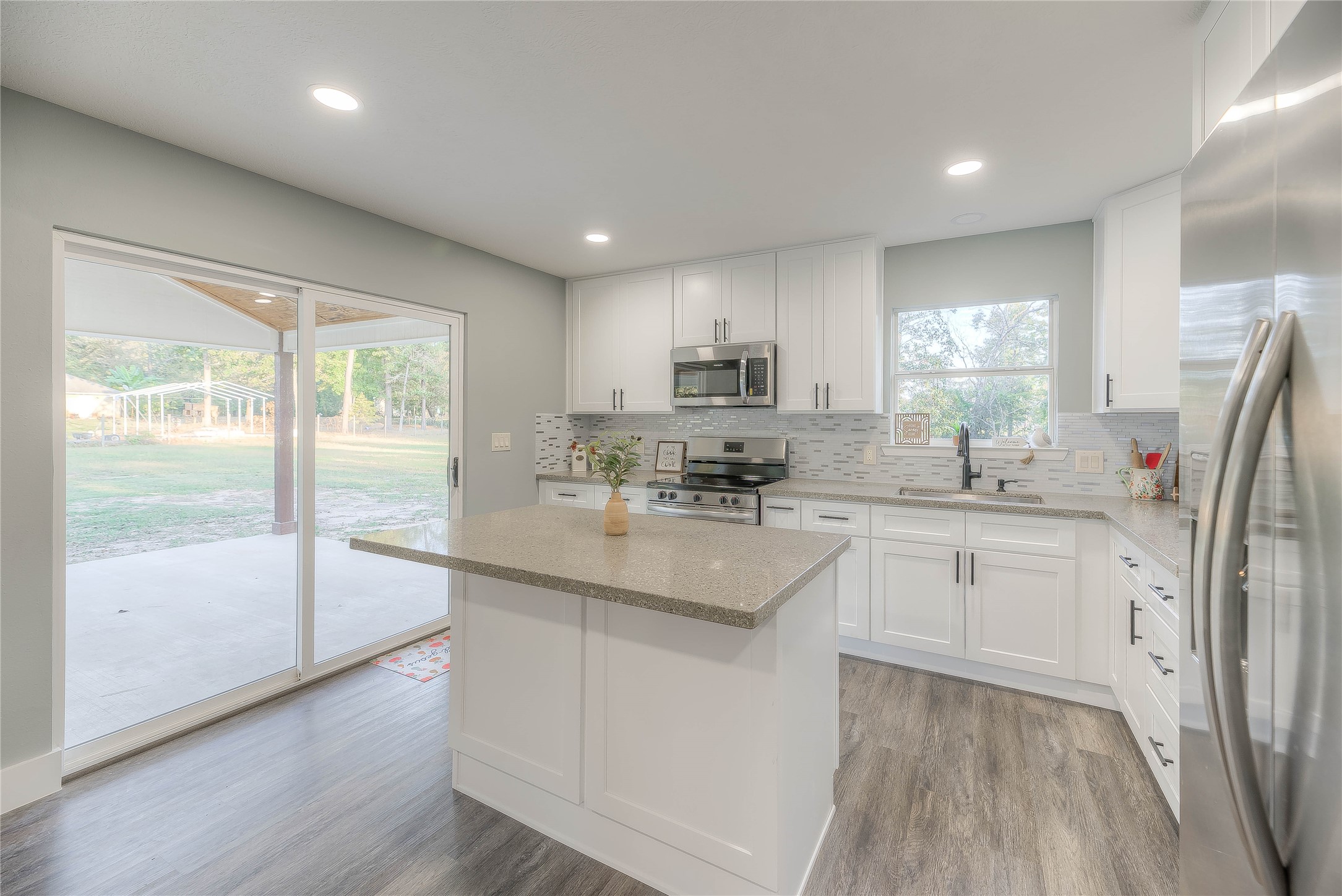 388 Sunrise Wood Road Goodrich, TX 77335 - Photo 9 of 33 a kitchen with stainless steel appliances granite countertop a refrigerator a sink dishwasher a stove and white cabinets with wooden floor