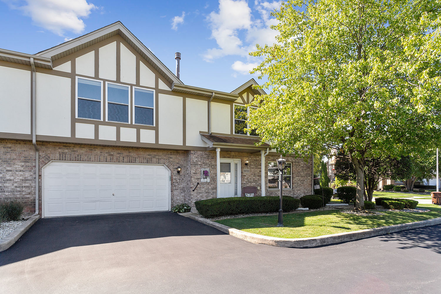 a front view of a house with a yard and trees