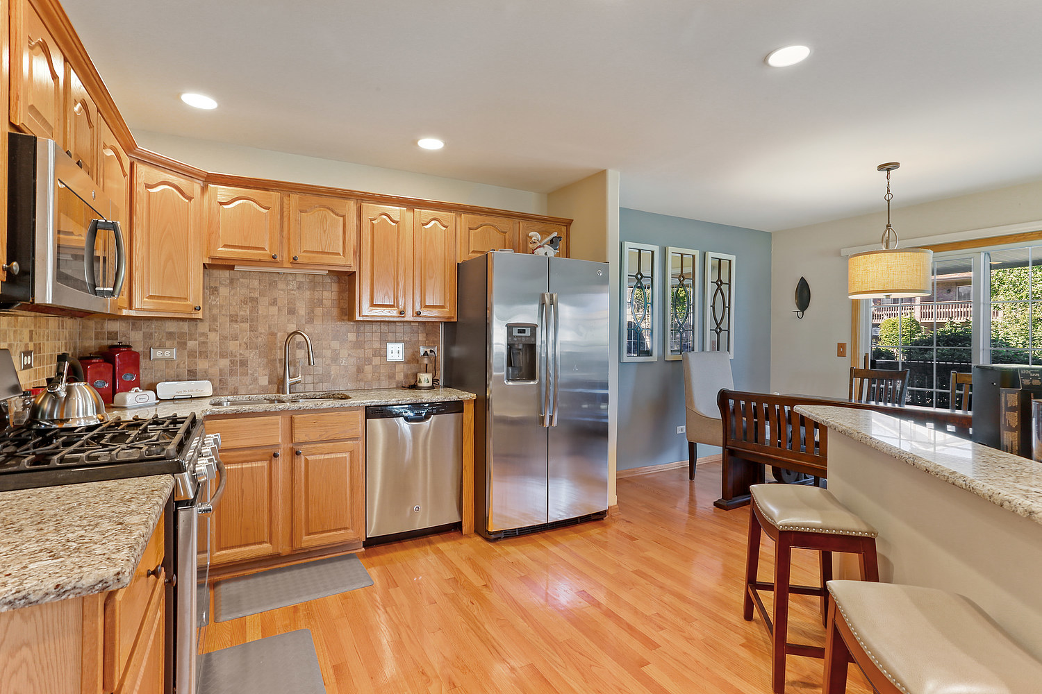 18133 Eagle Drive Tinley Park, IL 60477 - Photo 4 of 20 a kitchen with stainless steel appliances granite countertop a refrigerator a stove and a sink with cabinets