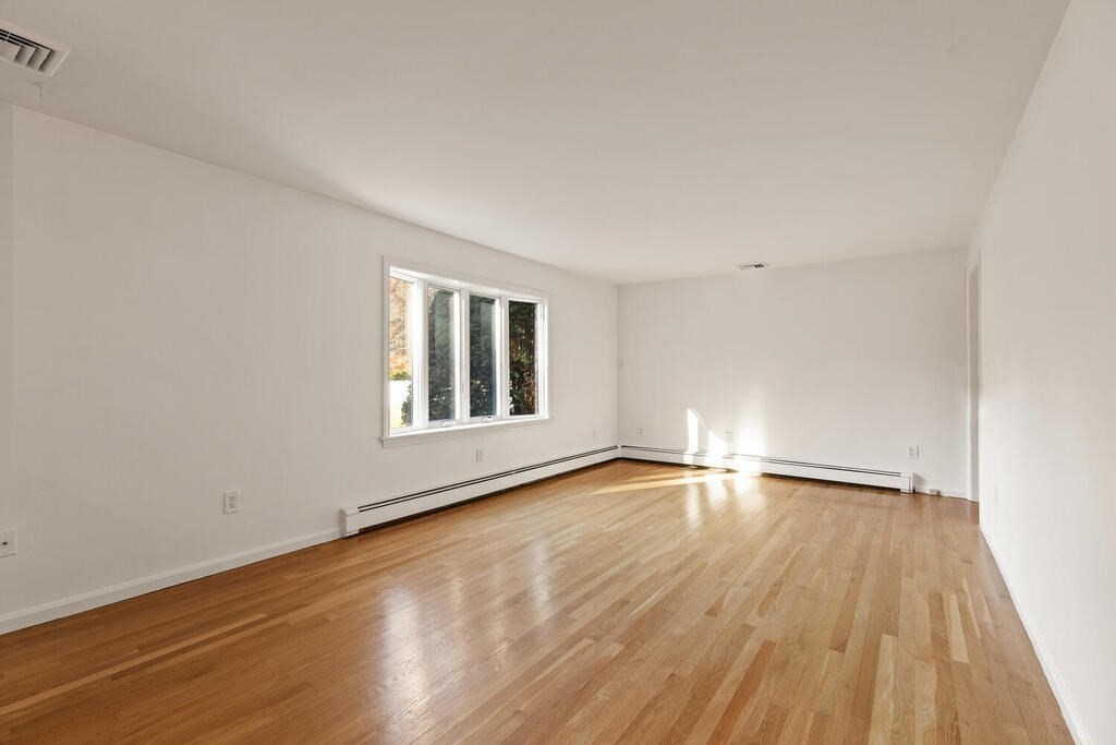 815 Great Road Stow, MA 01775 - Photo 7 of 32 a view of an empty room and wooden floor and a window