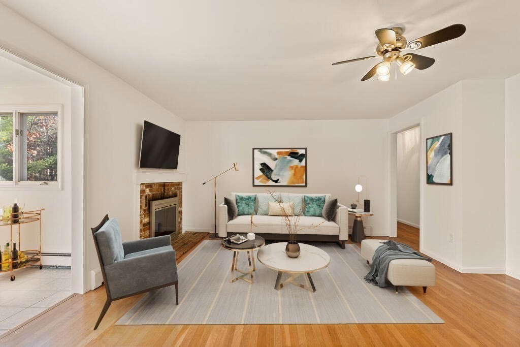 815 Great Road Stow, MA 01775 - Photo 9 of 32 a living room with furniture a fireplace and a flat screen tv