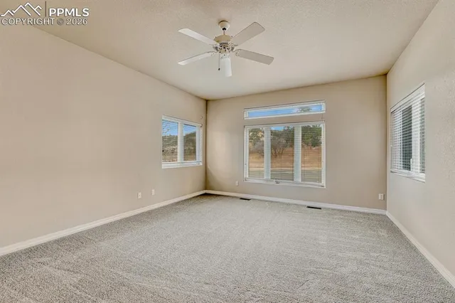 an empty room with fan and a ceiling fan