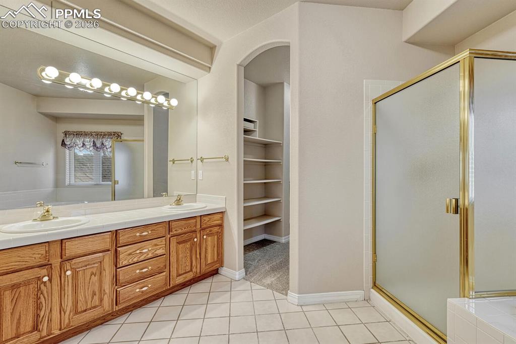 1665 Doe Run Point Colorado Springs, CO 80919 - Photo 19 of 49 a spacious bathroom with a double vanity sink a mirror and a shower