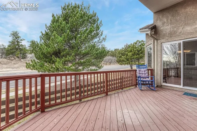 a view of a balcony with wooden floor and fence