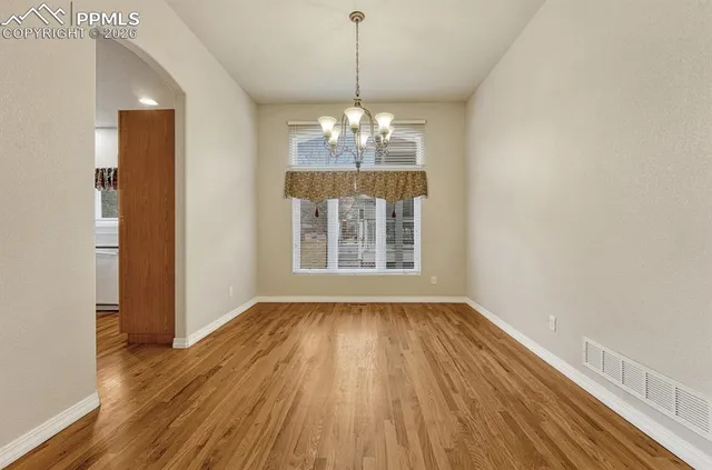 a view of a room with wooden floor and chandelier