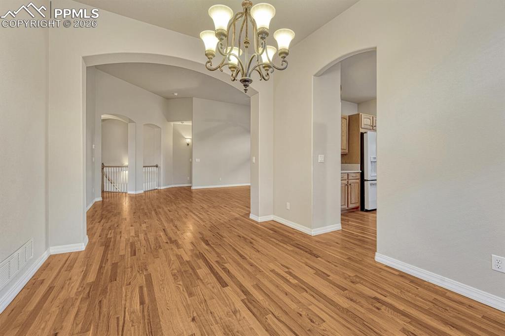 1665 Doe Run Point Colorado Springs, CO 80919 - Photo 10 of 49 a view of a room with wooden floor and chandelier