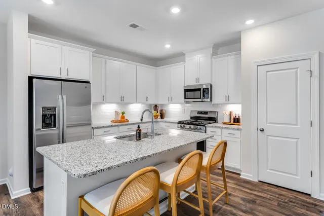a living room with furniture a dining table and chairs with wooden floor