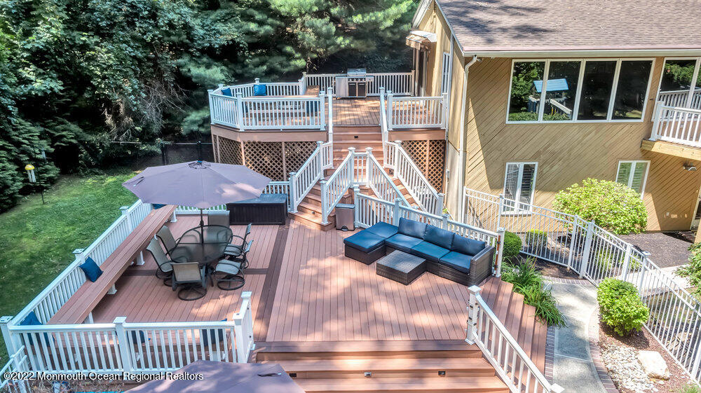 234 Red Hill Road Middletown, NJ 07748 - Photo 48 of 58 a view of a patio with table and chairs potted plants with wooden floor and fence