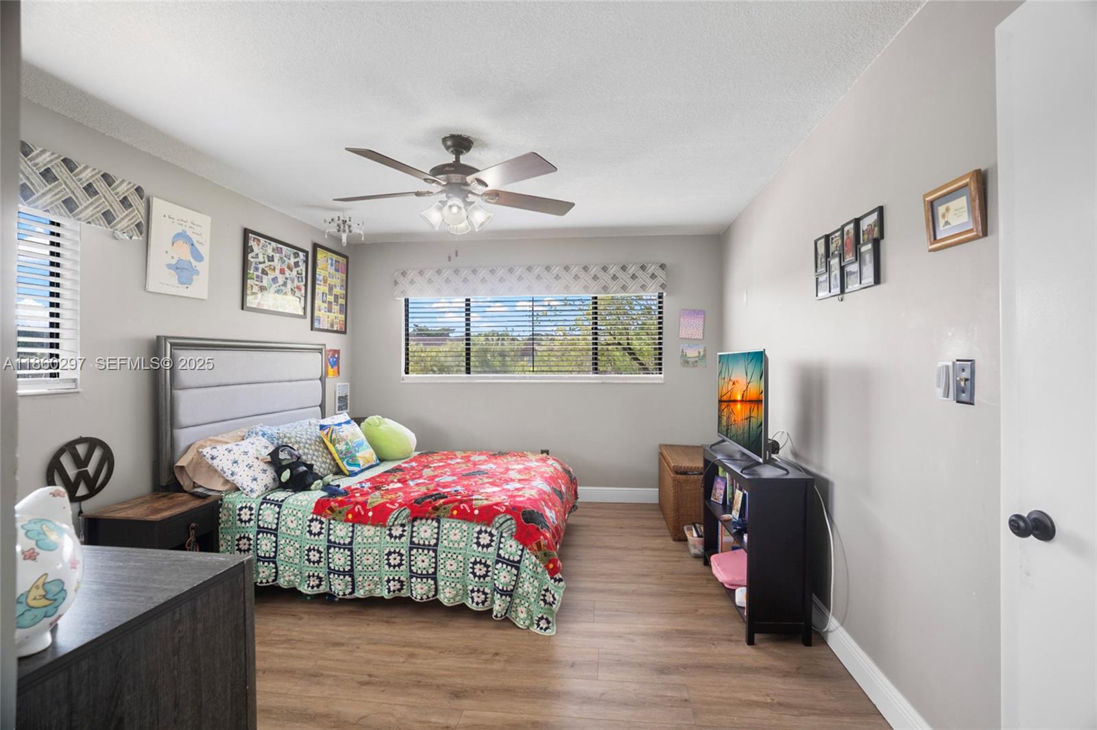 9606 West McNab Road, Unit 202 Tamarac, FL 33321 - Photo 19 of 29 a bedroom with bed a flat tv screen and a dresser