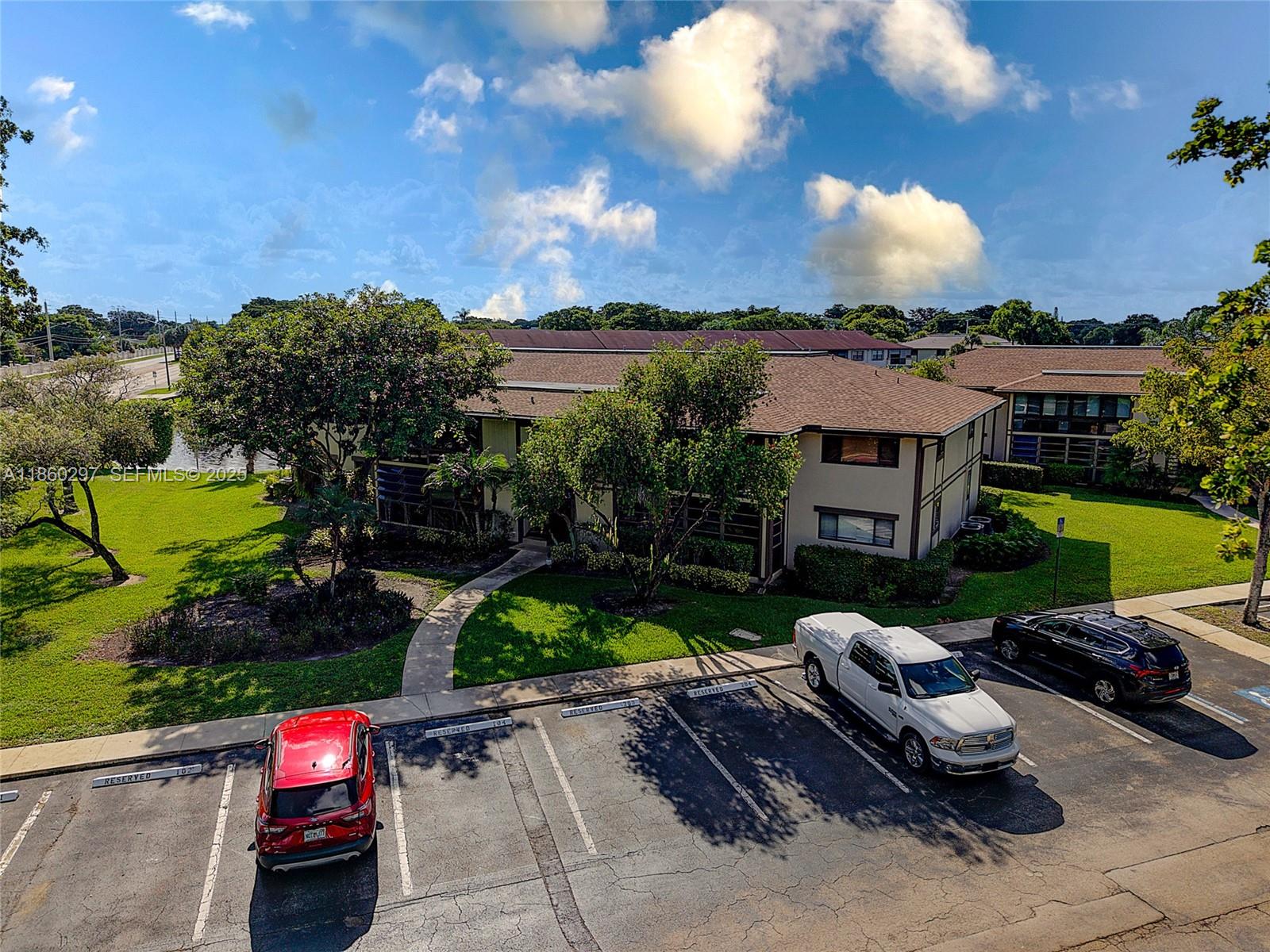 9606 West McNab Road, Unit 202 Tamarac, FL 33321 - Photo 24 of 29 a car parked in front of a house with a yard