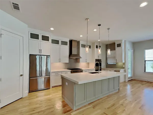 a kitchen with stainless steel appliances granite countertop a sink stove and refrigerator