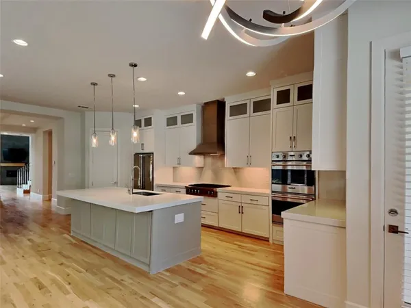 a large kitchen with stainless steel appliances kitchen island granite countertop a stove and a sink