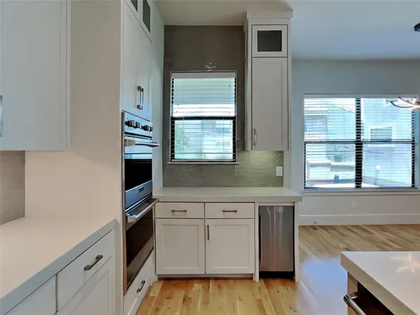 a kitchen with a sink a large window and stainless steel appliances