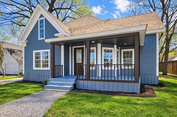 a view of a house with a yard and wooden fence