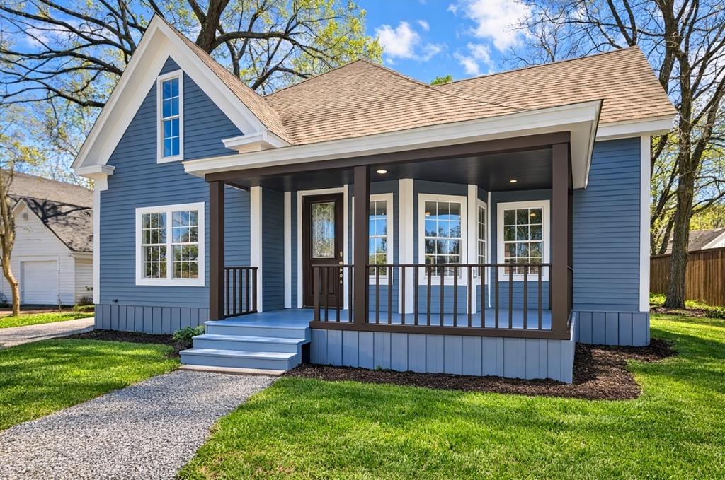 a view of a house with a yard and wooden fence