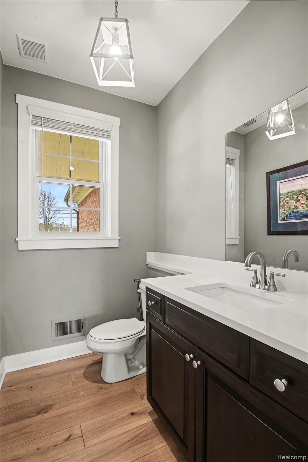 47705 Card Road Macomb, MI 48044 - Photo 20 of 53 Powder room featuring a single vanity with a white countertop, dark wood-finish cabinetry, brushed nickel hardware, and wood-finish flooring