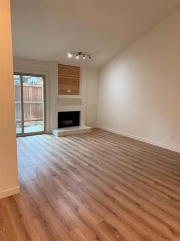 wooden floor fireplace and windows in an empty room