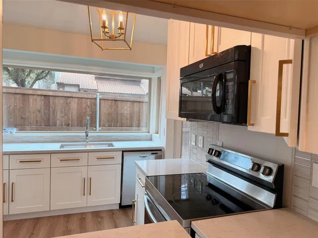 a kitchen with a stove a sink and a microwave