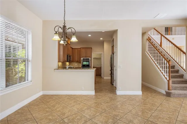 a view of a hallway with wooden floor and a chandelier