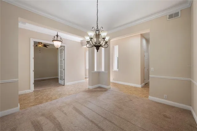 a view of a chandelier in big room and a bathroom