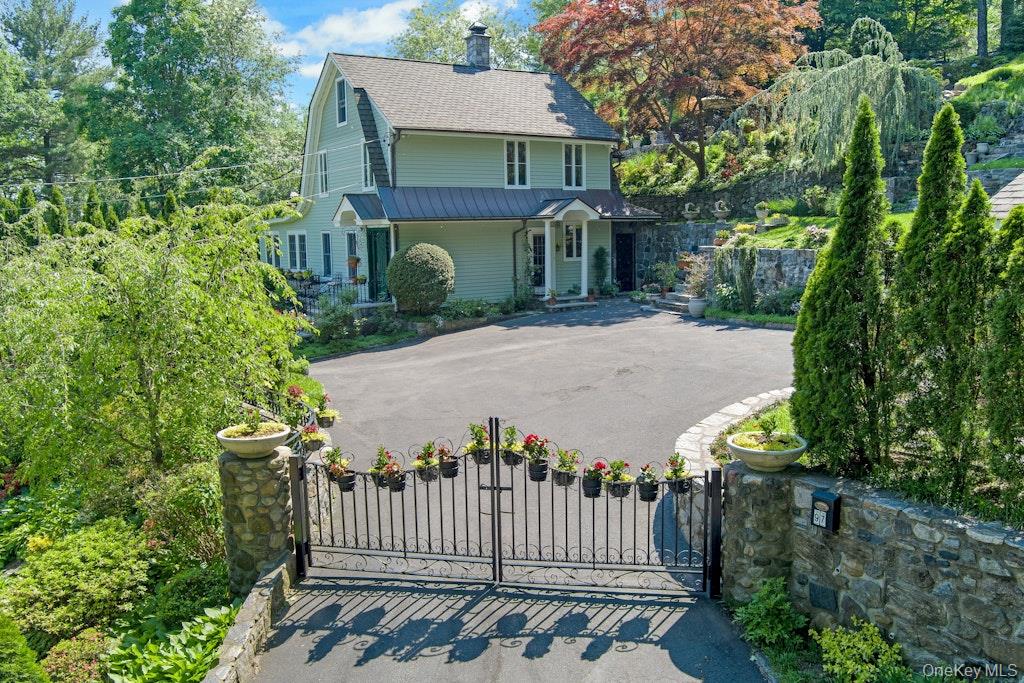 97 Underhill Road Scarsdale, NY 10583 - Photo 2 of 39 a view of a house with a small yard and plants