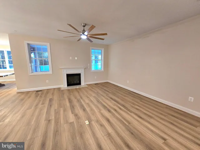 a view of empty room with fireplace and fan