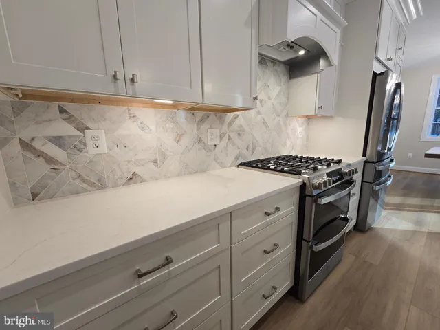 a kitchen with white cabinets and a stove