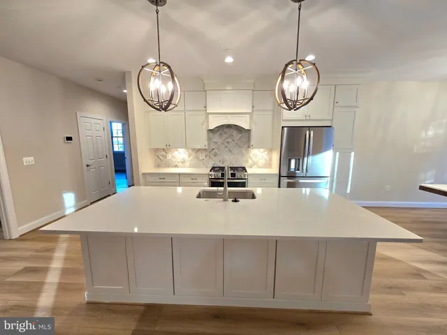 a view of a room with wooden floor and chandelier