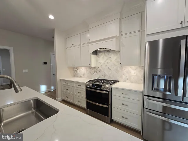 a kitchen with white cabinets and stainless steel appliances