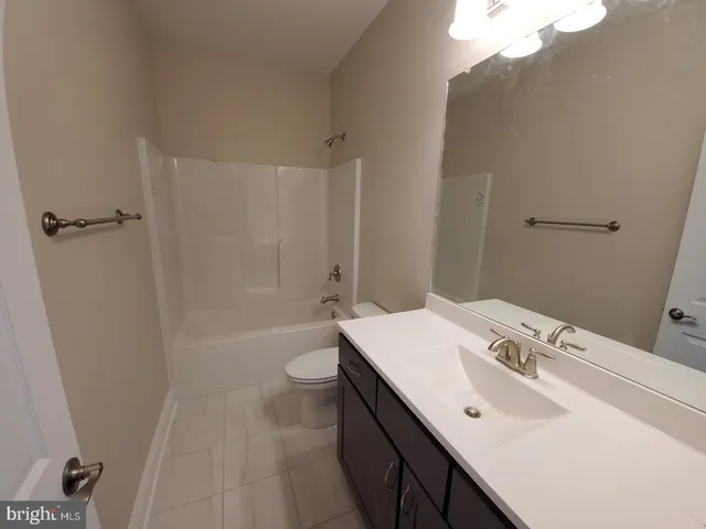 a bathroom with a sink a toilet a mirror and shower