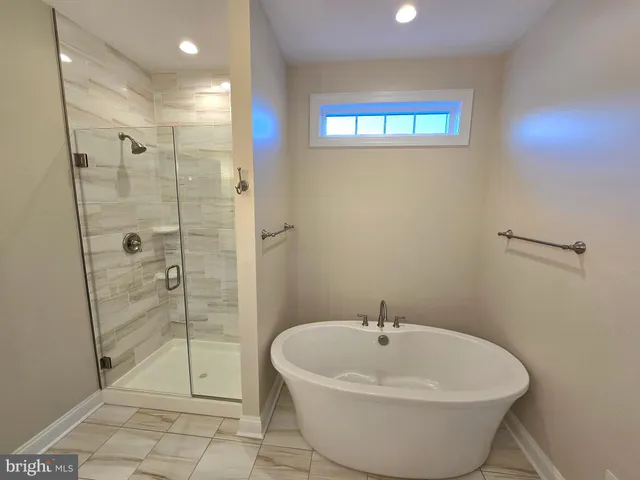 a white bath tub sitting in a bathroom and shower