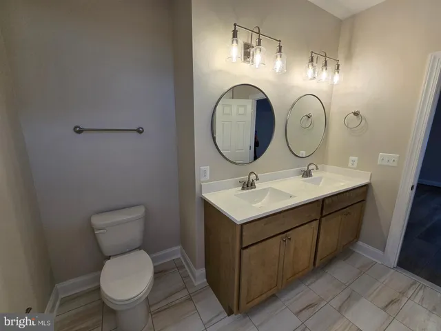 a bathroom with a toilet sink and mirror