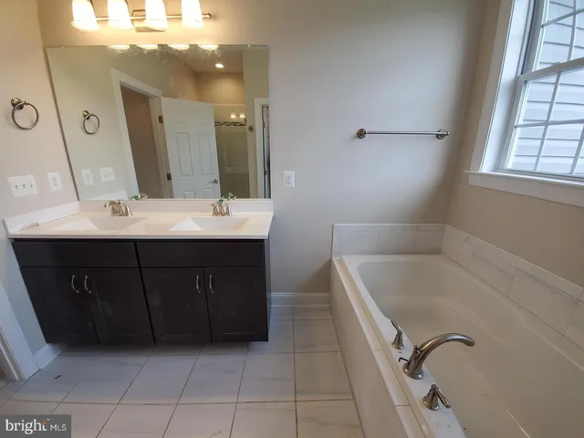 a bathroom with a tub sink and mirror