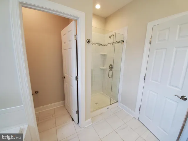 a bathroom with a shower and a glass door
