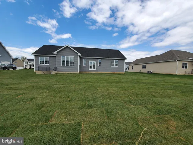 a view of a house with a big yard and large trees