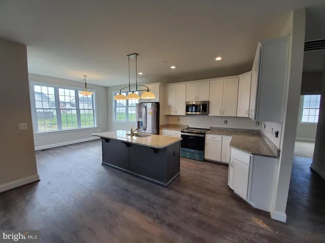 a large kitchen with a lot of counter space and wooden floor