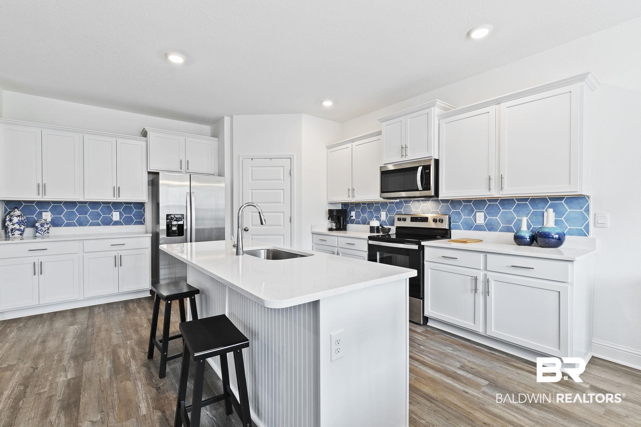 1141 Pencarro Boulevard Foley, AL 36535 - Photo 17 of 70 Kitchen with sink, a center island with sink, white cabinets, and appliances with stainless steel finishes