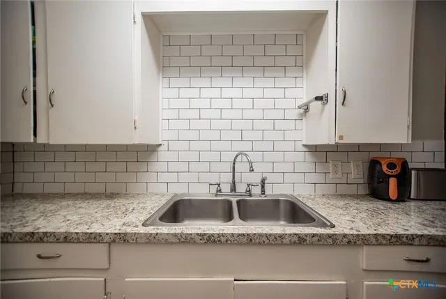 a bathroom with a granite countertop sink