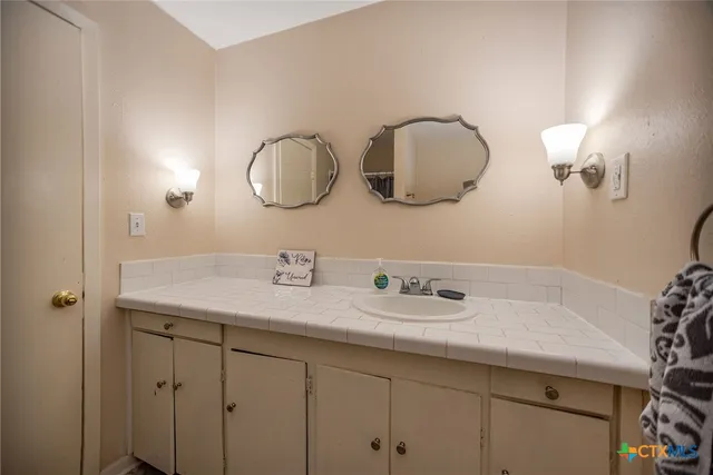 a bathroom with a double vanity sink and a mirror
