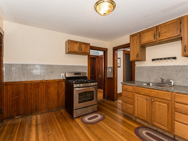 348 Lagrange Street Boston, MA 02132 - Photo 18 of 25 a kitchen with stainless steel appliances granite countertop a stove a sink and a microwave